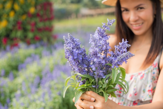 Ritratto esterno di una bella donna di mezza età dell&#39;Asia. ragazza attraente in un campo con i fiori