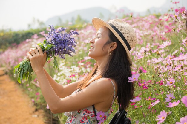 Ritratto esterno di una bella donna di mezza età dell&#39;Asia. ragazza attraente in un campo con i fiori