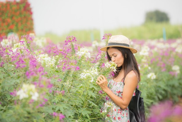 Ritratto esterno di una bella donna di mezza età dell&#39;Asia. ragazza attraente in un campo con i fiori