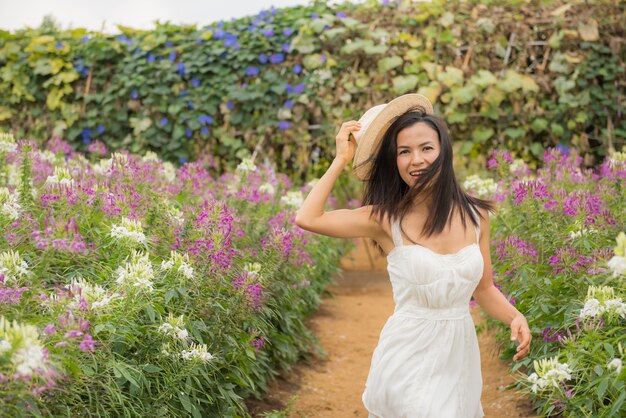 Ritratto esterno di una bella donna di mezza età dell&#39;Asia. ragazza attraente in un campo con i fiori