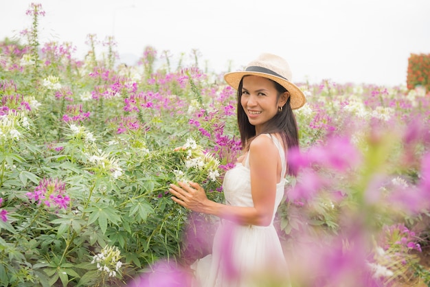 Ritratto esterno di una bella donna di mezza età dell&#39;Asia. ragazza attraente in un campo con i fiori