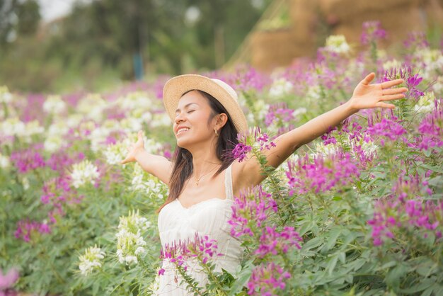 Ritratto esterno di una bella donna di mezza età dell&#39;Asia. ragazza attraente in un campo con i fiori