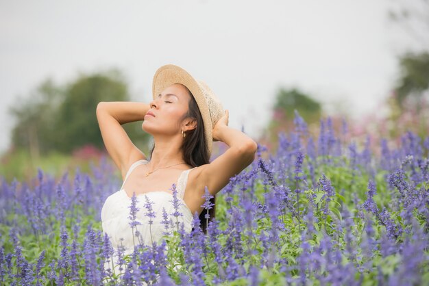 Ritratto esterno di una bella donna di mezza età dell&#39;Asia. ragazza attraente in un campo con i fiori