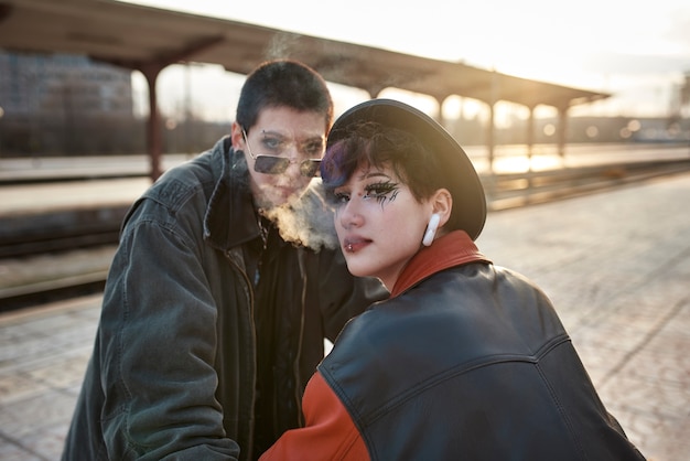 Ritratto estetico pop punk di donne in posa nella stazione ferroviaria