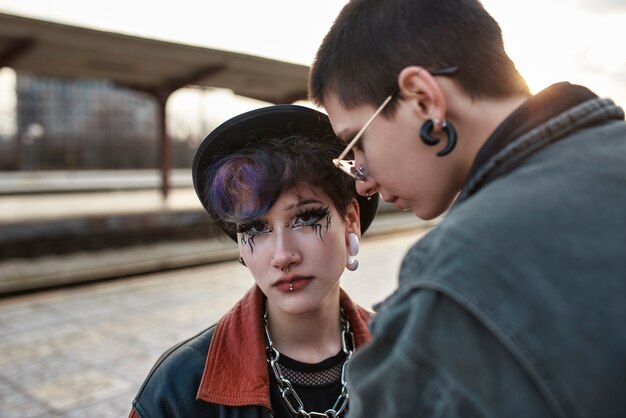 Ritratto estetico pop punk di donne in posa nella stazione ferroviaria