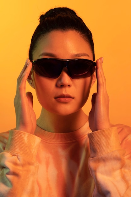 Ritratto giovane donna asiatica che indossa occhiali da sole