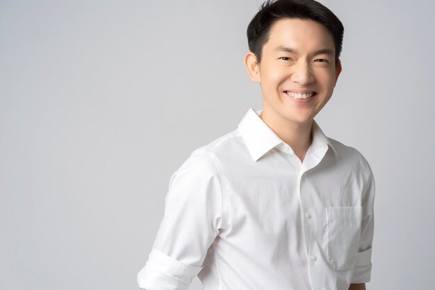 Ritratto in studio di un attraente giovane uomo d'affari asiatico camicia bianca mezzo corpo isolato su sfondo grigio