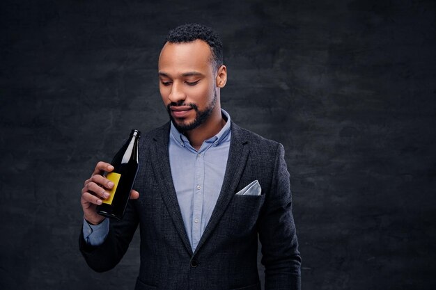 Ritratto in studio di un elegante maschio nero americano vestito con un abito da degustazione di birra artigianale.