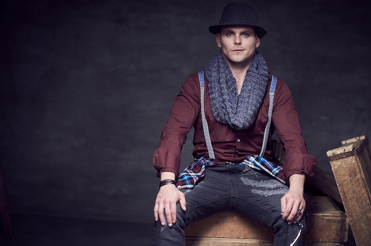 Foto gratuito ritratto in studio di un uomo casual elegante vestito con una camicia rossa e bretelle.