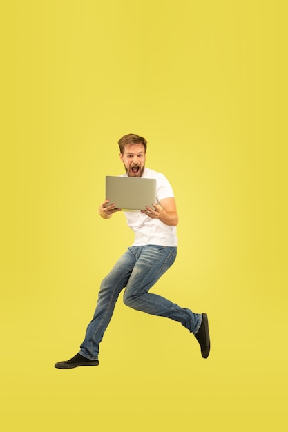 Ritratto integrale dell'uomo di salto felice isolato su colore giallo