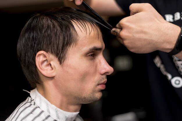 Ritratto laterale di un uomo che ottiene un taglio di capelli