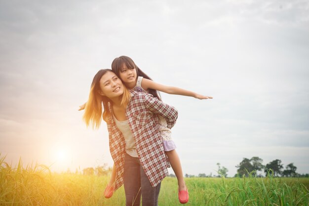 Ritratto mamma e figlia giocare all&#39;aperto, godendo il tempo della famiglia.