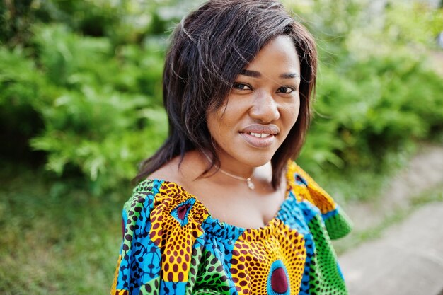 Ritratto ravvicinato di ragazza afroamericana in camicia colorata seduta all'aperto Donna nera alla moda
