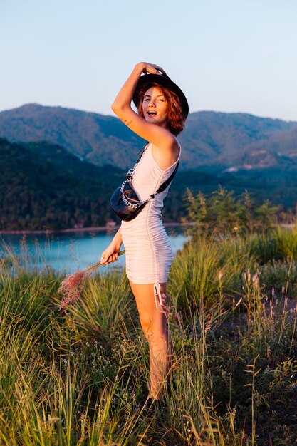 Ritratto romantico di giovane donna caucasica in abito estivo godendo di relax nel parco sulla montagna con incredibile vista sul mare tropicale Femmina in vacanza viaggia in Thailandia Donna felice al tramonto