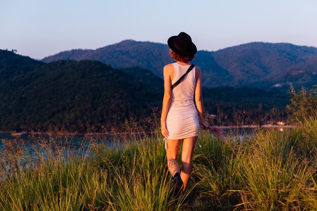 Ritratto romantico di giovane donna caucasica in abito estivo godendo di relax nel parco sulla montagna con incredibile vista sul mare tropicale Femmina in vacanza viaggia in Thailandia Donna felice al tramonto