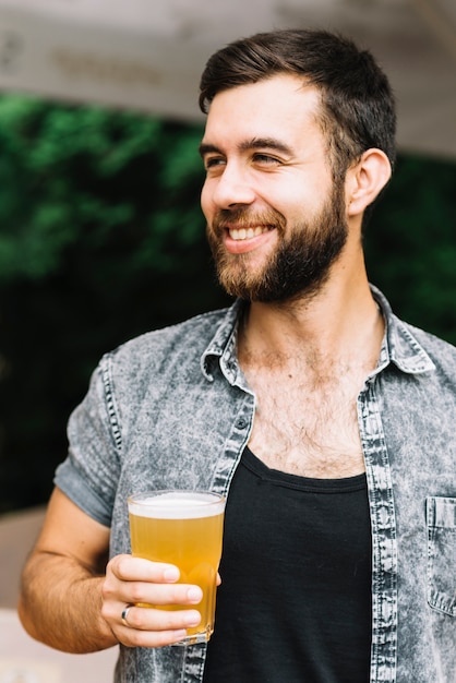 Ritratto sorridente dell&#39;uomo che tiene il vetro di birra