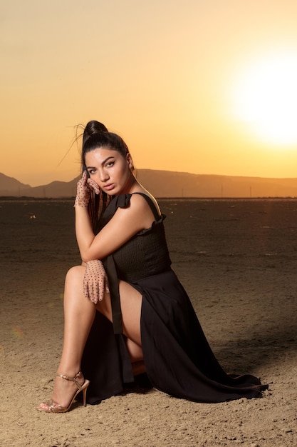 Ritratto verticale di giovane ragazza calda nel deserto al tramonto Foto di alta qualità