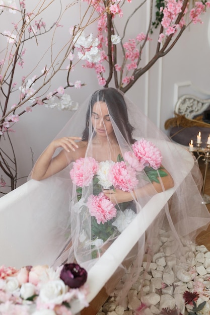 Ritratto verticale di giovane ragazza seduta in una vasca da bagno e guardando verso il basso Foto di alta qualità