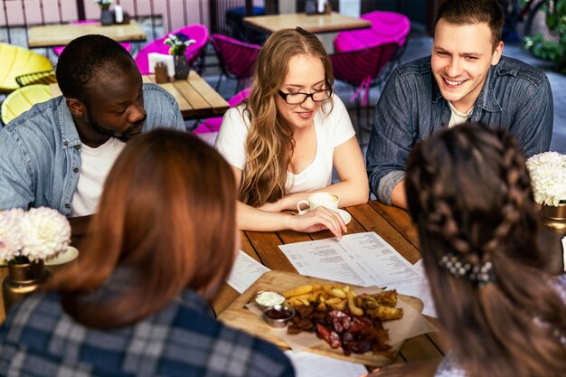 Riunione informale dei compagni di lavoro dopo il lavoro al piccolo bar, ragazze e ragazzi