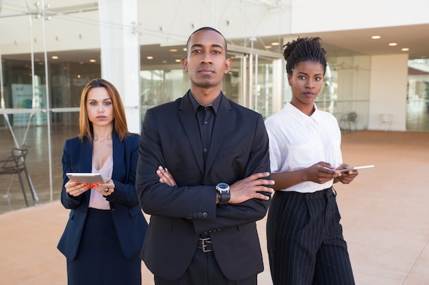 Riuscito gruppo di affari che posa nel corridoio dell&#39;ufficio