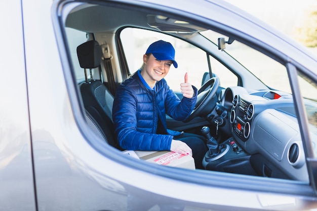 Riuscito lavoratore di consegna che mostra pollice in su