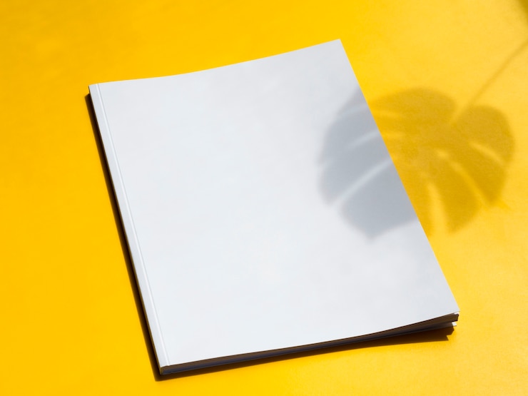 Foto gratuito rivista in bianco del primo piano con fondo giallo