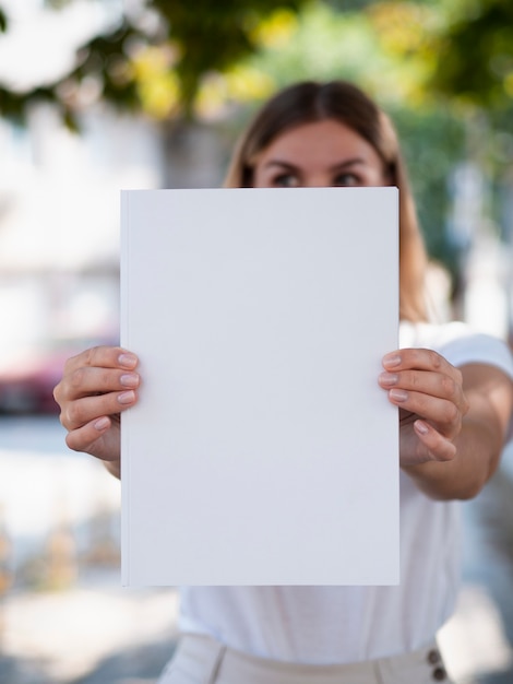 Rivista in bianco del primo piano tenuta da una donna