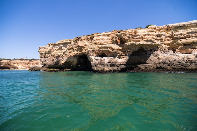 Rocce, scogliere e paesaggio dell'oceano al litorale in Algarve, Portogallo vista dalla barca