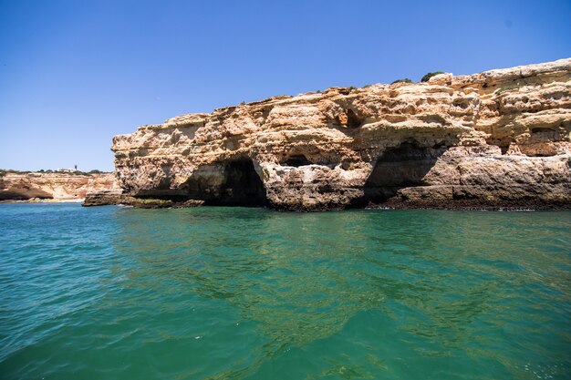 Rocce, scogliere e paesaggio dell'oceano al litorale in Algarve, Portogallo vista dalla barca