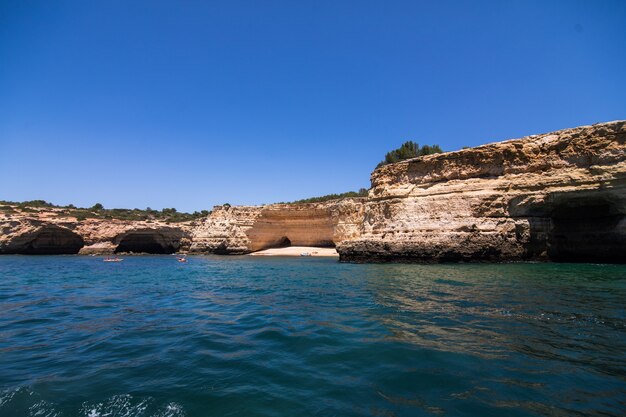 Rocce, scogliere e paesaggio dell'oceano al litorale in Algarve, Portogallo vista dalla barca