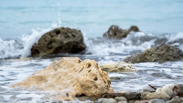 Rocce sulla costa del mare, schiuma e onde