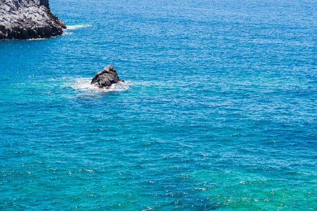 Roccia a lungo tiro solitario nel mare cristallino