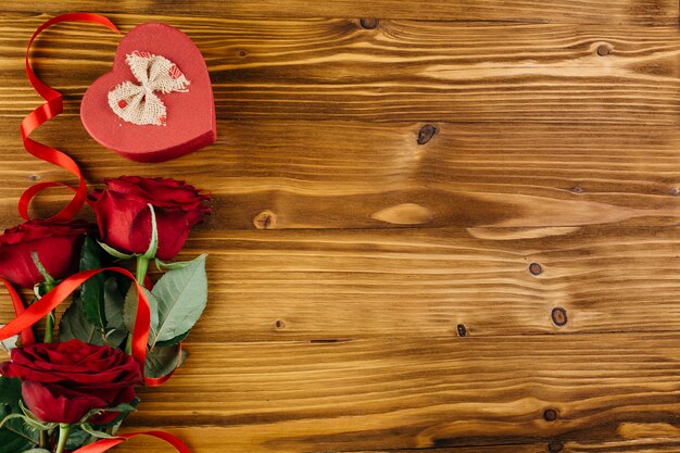 Rose rosse con scatola a forma di cuore sul tavolo