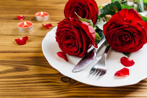 Rose rosse sul piatto bianco