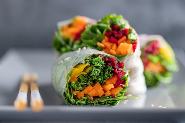 Rotoli di carta di riso vegani con verdure e sesamo serviti su piatto pronti da mangiare