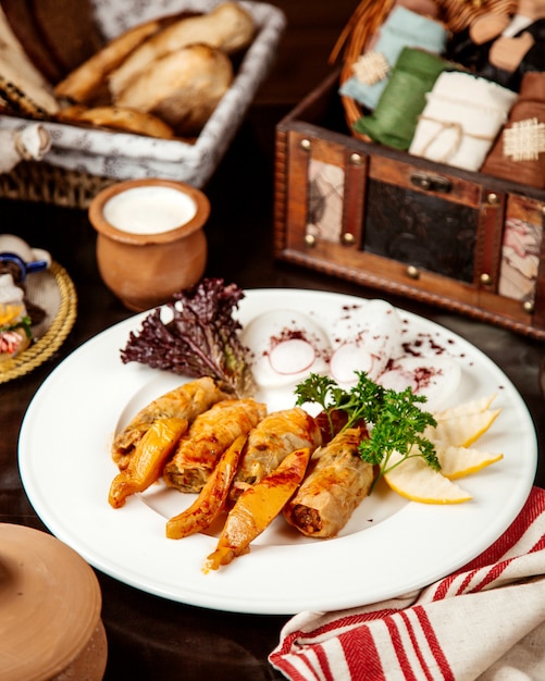 Rotoli di cavolo di vista laterale con fette di mele cotogne cipolla e yogurt