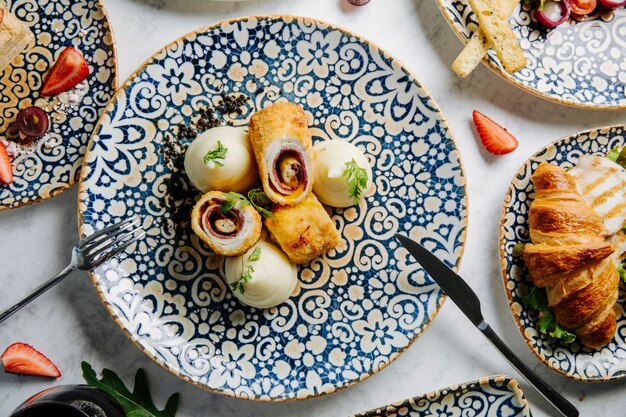 Rotoli di pasta dolce con crema alla vaniglia in piatto decorativo.