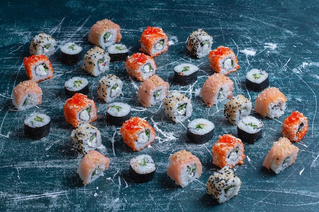 Rotoli di sushi assortiti tradizionali sull'azzurro.