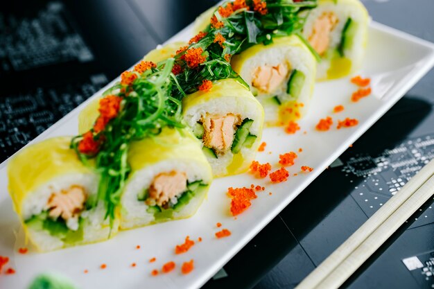 Rotoli di sushi con salmone fritto e cetriolo conditi con alghe