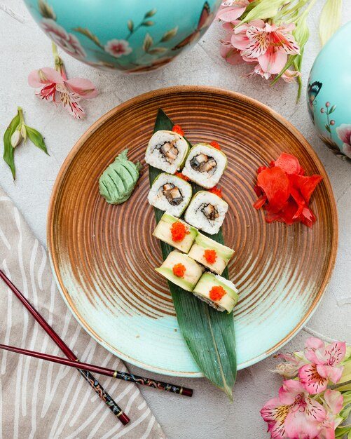 Rotoli di sushi dentro il piatto di progettazione di marrone blu.