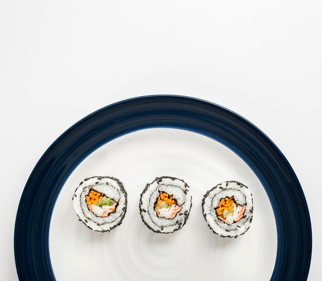 Rotoli di sushi di Maki sul piatto bianco e blu