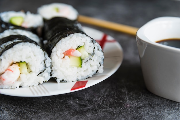 Rotoli di sushi, salsa di soia e bacchette