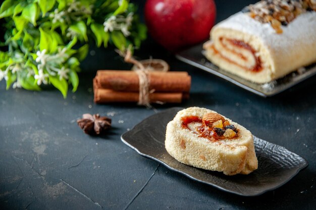 Rotolo delizioso del biscotto di vista frontale su zucchero dolce del dessert della torta del biscotto del biscotto del tè dello sfondo scuro