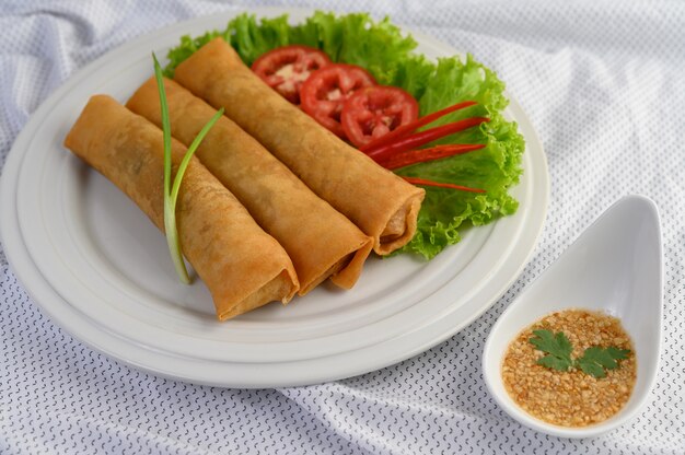Rotolo dell'uovo o Fried Spring Rolls sull'alimento tailandese del piatto bianco. .