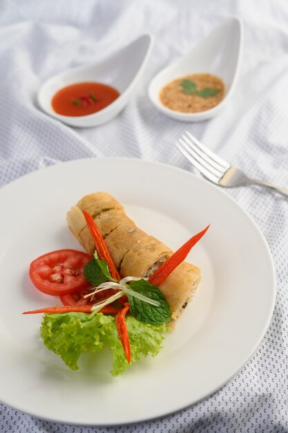 Rotolo dell'uovo o Fried Spring Rolls sull'alimento tailandese del piatto bianco. .