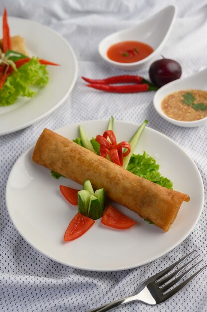Rotolo dell'uovo o Fried Spring Rolls sull'alimento tailandese del piatto bianco. .