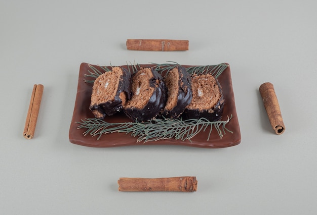 Rotolo di cioccolato dolce a fette con bastoncini di cannella.