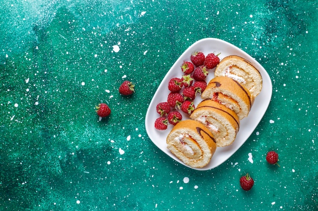 Rotolo di torta ai lamponi con frutti di bosco freschi.