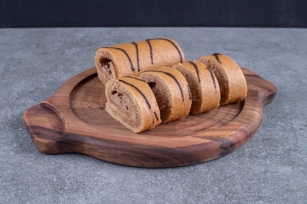 Rotolo di torta al cioccolato su piatto di legno