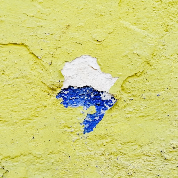 Rotto muro giallo con blu